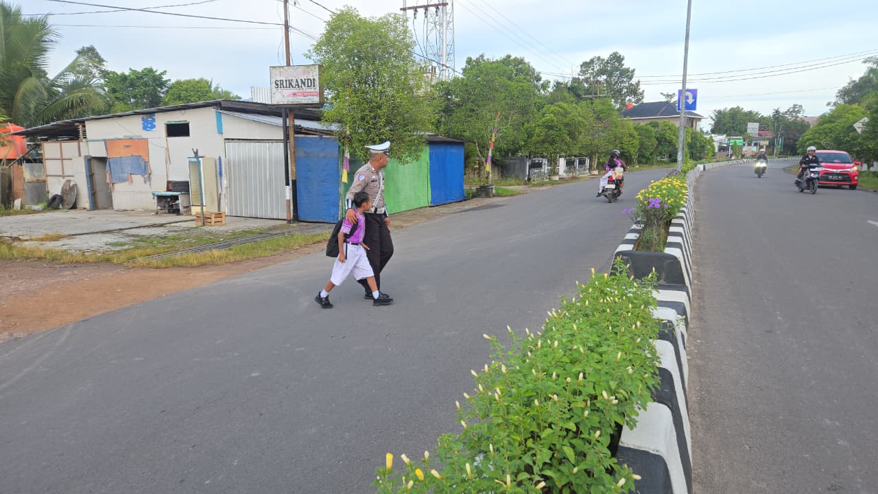 Personil Sat Lantas Lamandau Bantu Menyebrangkan Anak Sekolah
