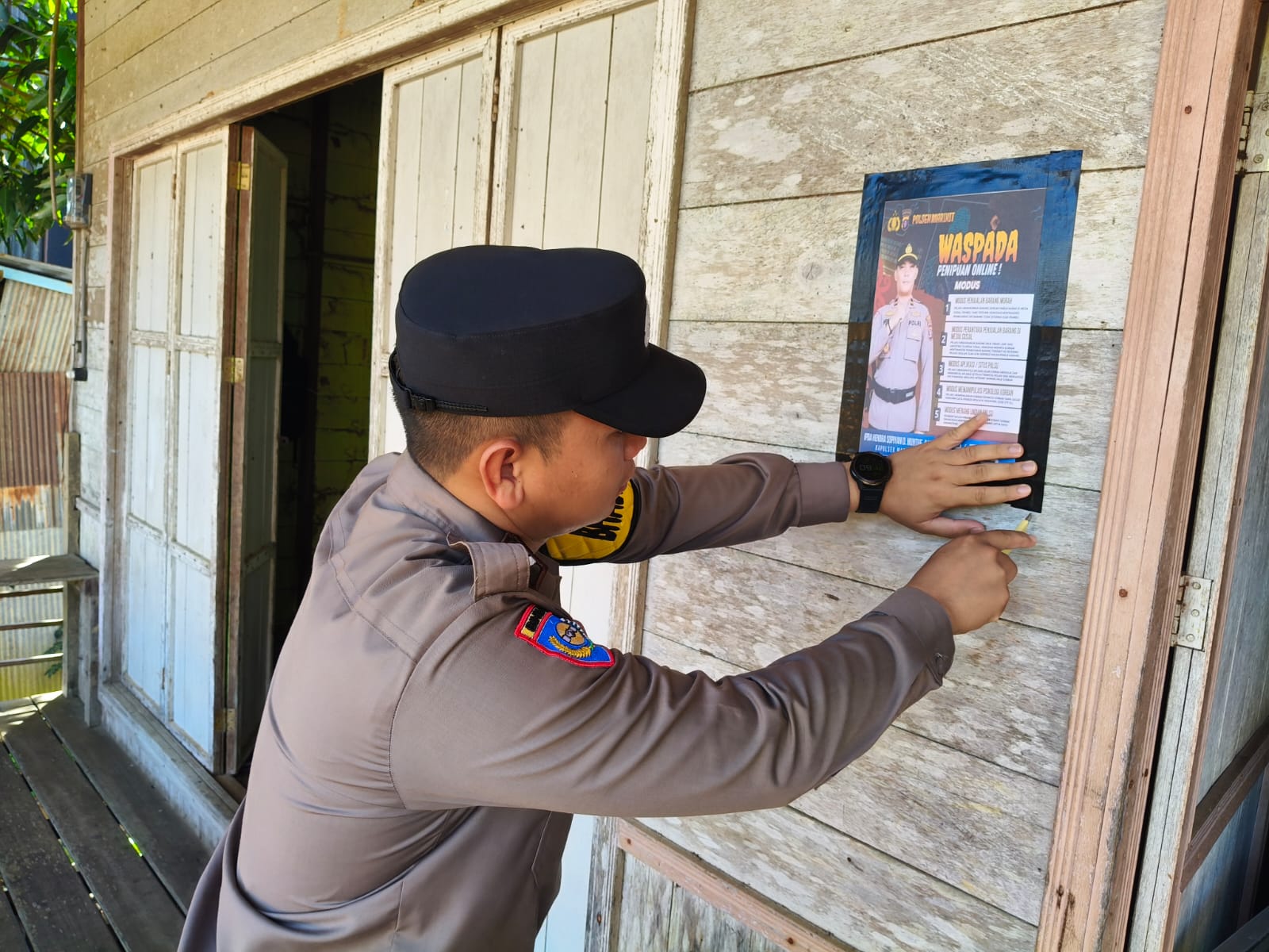 Personil Polsek Marikit Ajak Warga Waspada Penipuan Online Lewat Pemasangan Brosur / Pamflet.